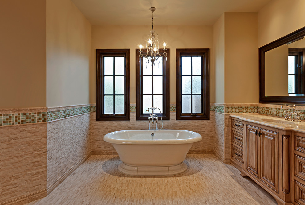 Aménagement d'une grande douche en alcôve principale méditerranéenne en bois brun avec un placard avec porte à panneau surélevé, une baignoire indépendante, un carrelage bleu, un carrelage marron, mosaïque, un mur beige, un sol en carrelage de céramique, un lavabo encastré et un plan de toilette en granite.