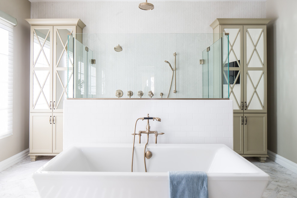 Inredning av ett medelhavsstil en-suite badrum, med beige skåp, ett fristående badkar, vit kakel, marmorgolv, luckor med infälld panel, en dusch i en alkov, mosaik, grå väggar, vitt golv och dusch med gångjärnsdörr