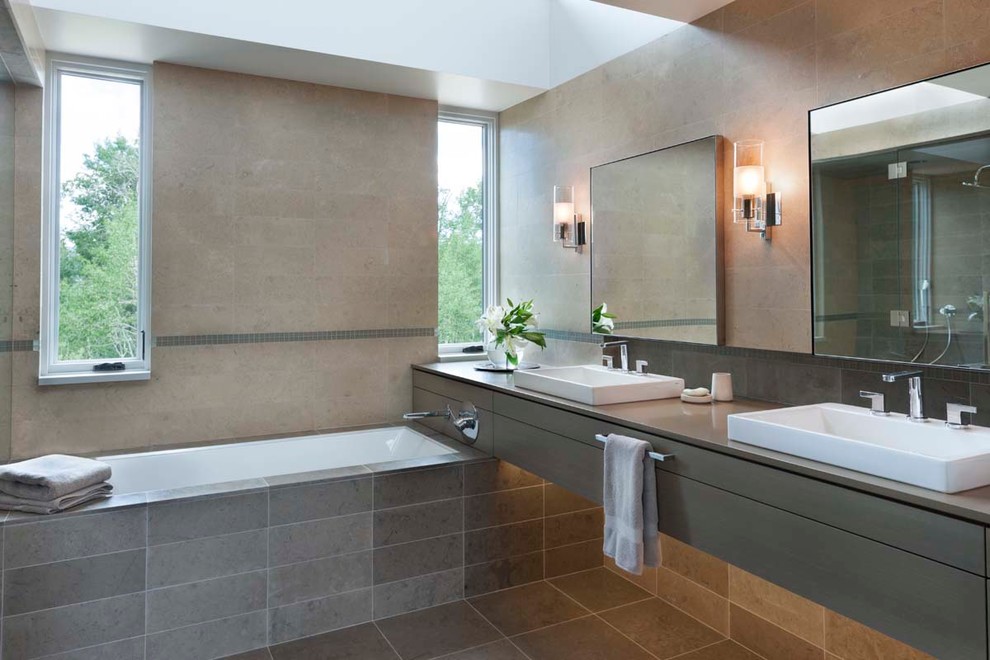 Photo of a large contemporary ensuite bathroom in Denver with flat-panel cabinets, grey cabinets, a built-in bath, beige walls, ceramic flooring, a pedestal sink, porcelain tiles and engineered stone worktops.