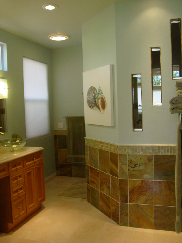 Foto de cuarto de baño actual con lavabo sobreencimera, puertas de armario de madera oscura, encimera de cuarzo compacto, ducha doble, baldosas y/o azulejos multicolor y baldosas y/o azulejos de piedra