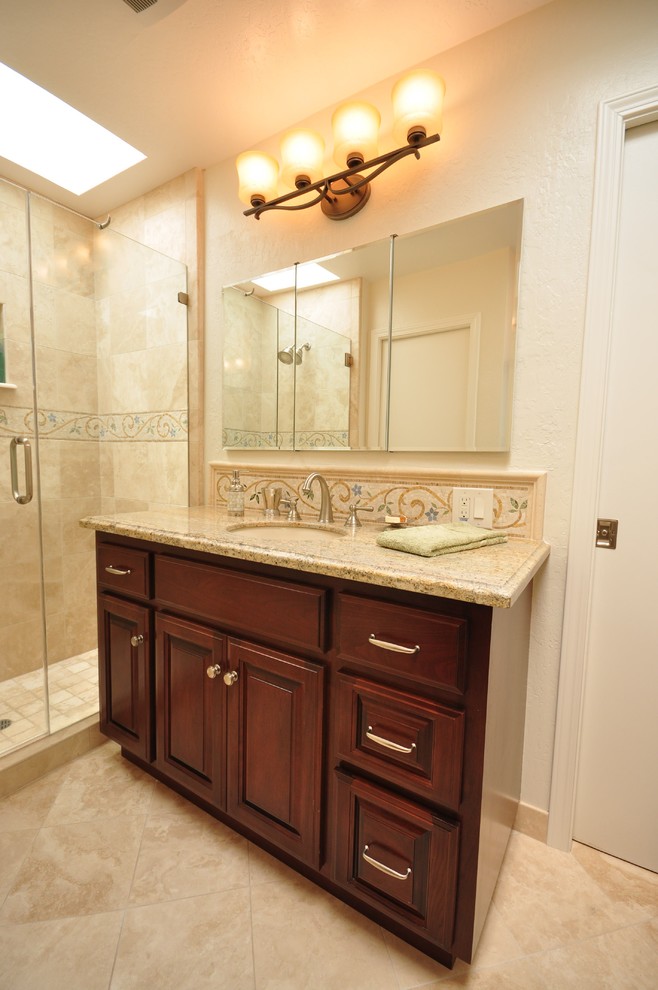 Foto de cuarto de baño tradicional con armarios con paneles con relieve y puertas de armario de madera en tonos medios