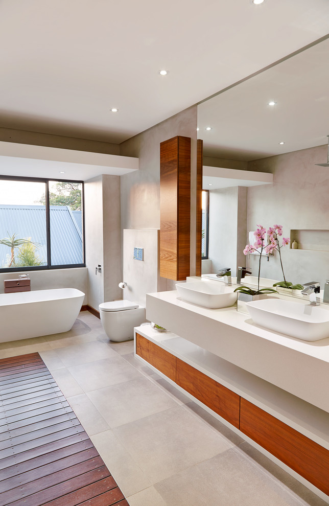 Example of a trendy white tile freestanding bathtub design with a vessel sink and flat-panel cabinets