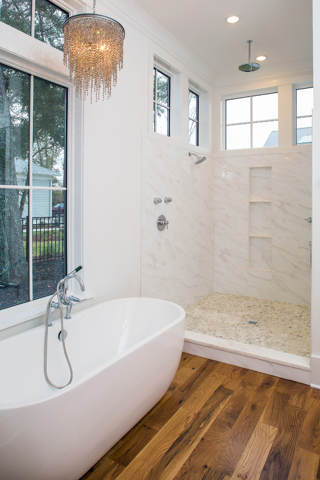 Exemple d'une salle de bain principale moderne de taille moyenne avec un placard à porte plane, des portes de placard blanches, une baignoire indépendante, une douche ouverte, WC séparés, un carrelage blanc, un carrelage de pierre, un sol en bois brun, un lavabo encastré et un plan de toilette en marbre.