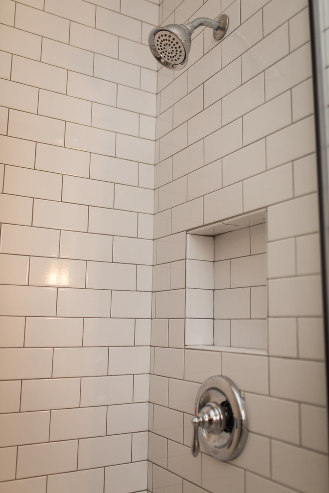 Cette image montre une salle de bain traditionnelle de taille moyenne avec un carrelage blanc, un carrelage métro, un mur blanc, un sol en carrelage de céramique, un lavabo de ferme, un sol blanc et une cabine de douche à porte battante.