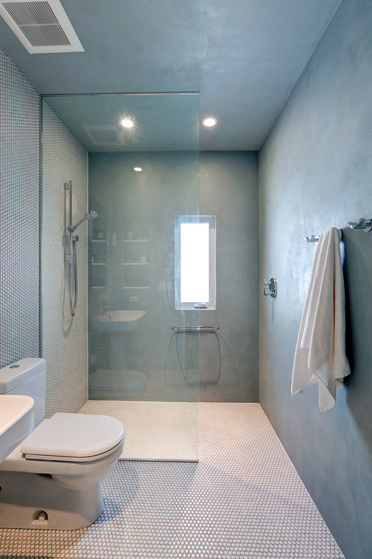 Diseño de cuarto de baño moderno de tamaño medio con lavabo con pedestal, ducha a ras de suelo, sanitario de dos piezas, baldosas y/o azulejos blancos, baldosas y/o azulejos en mosaico, paredes azules, suelo con mosaicos de baldosas y aseo y ducha