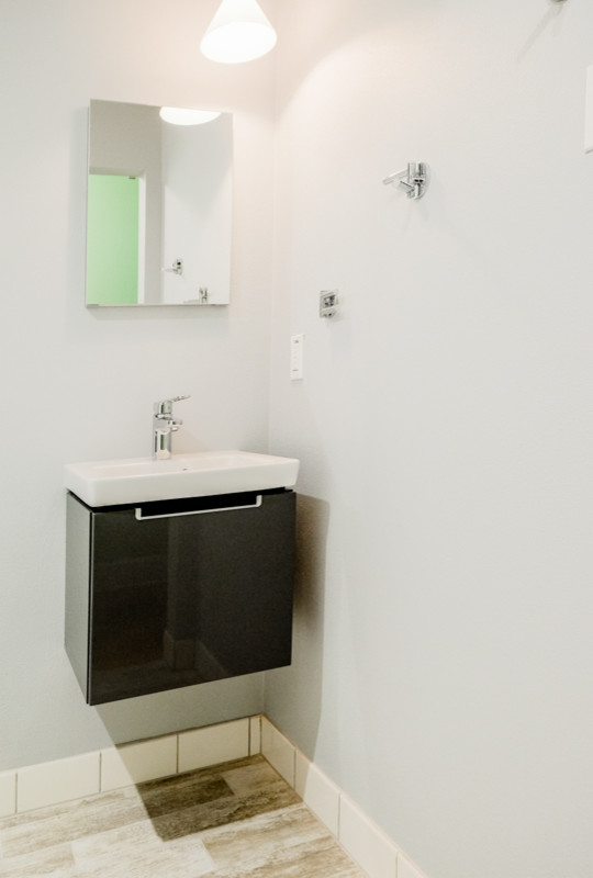 Esempio di una piccola stanza da bagno padronale design con lavabo da incasso, ante in legno scuro, piastrelle bianche, piastrelle diamantate e parquet chiaro