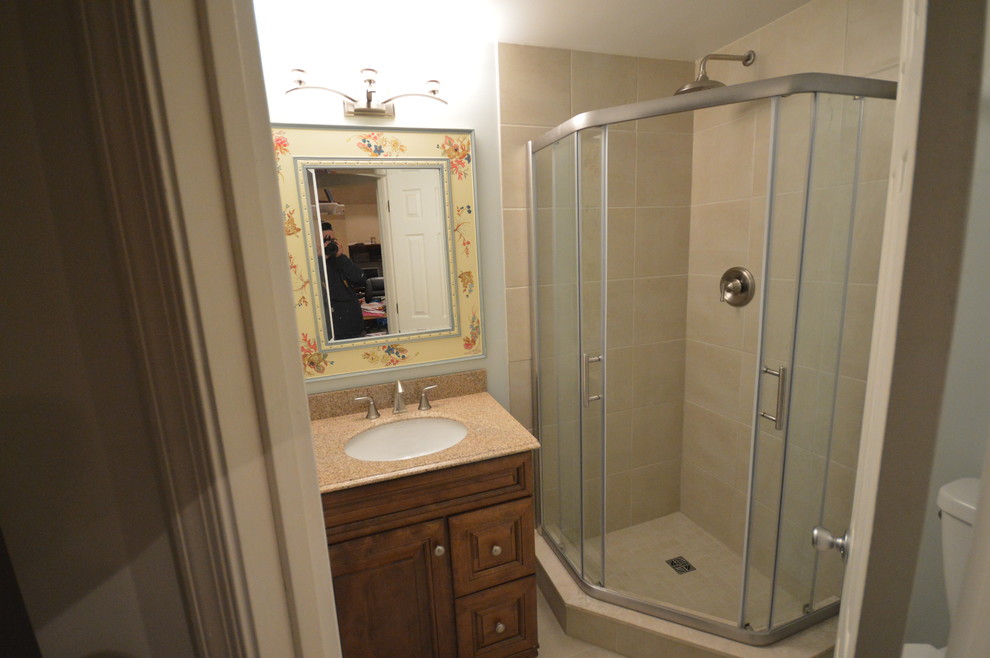 На фото: ванная комната в классическом стиле с врезной раковиной, фасадами с выступающей филенкой, фасадами цвета дерева среднего тона, угловым душем, унитазом-моноблоком и белыми стенами