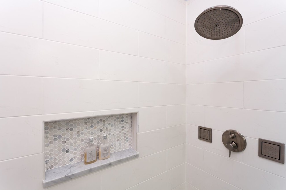 Foto på ett stort vintage badrum med dusch, med ett undermonterad handfat, luckor med profilerade fronter, vita skåp, marmorbänkskiva, en dusch i en alkov, en toalettstol med separat cisternkåpa, vit kakel, keramikplattor, blå väggar och klinkergolv i keramik