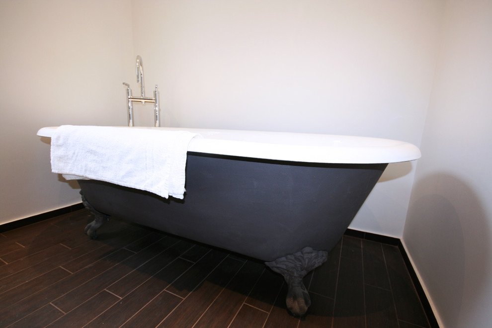 Photo of a medium sized classic family bathroom in Other with a freestanding bath, a built-in shower, a wall mounted toilet, black tiles and black walls.