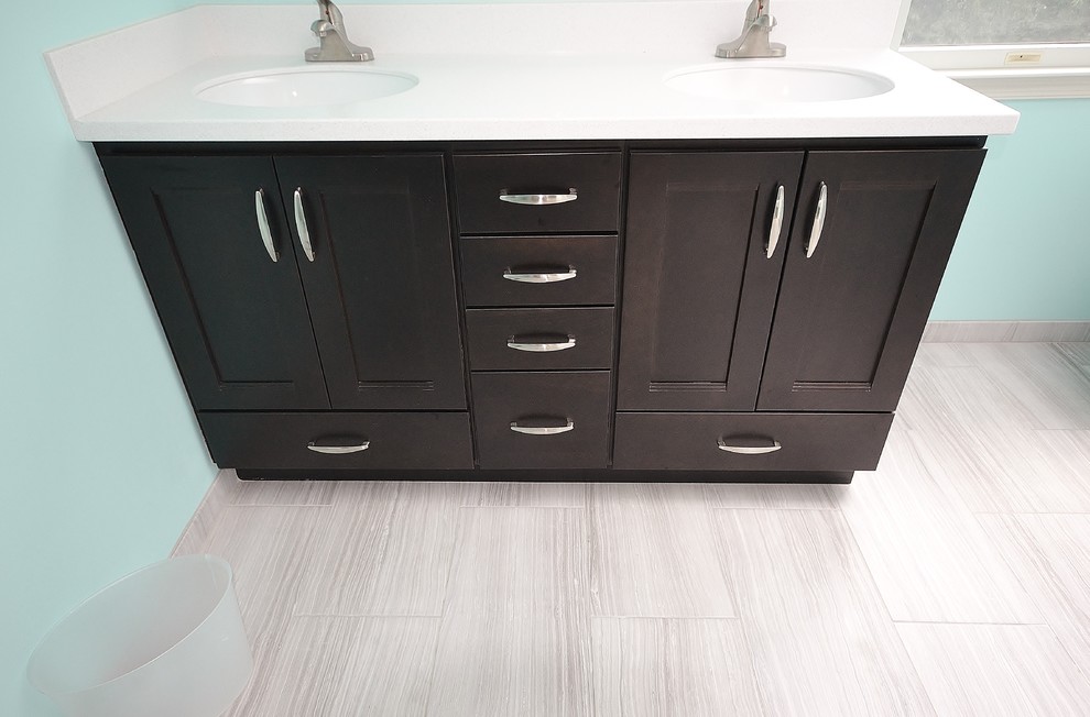Example of a mid-sized transitional master ceramic tile and gray tile ceramic tile and gray floor bathroom design in Philadelphia with an undermount sink, dark wood cabinets, solid surface countertops, a one-piece toilet, blue walls, shaker cabinets and a hinged shower door