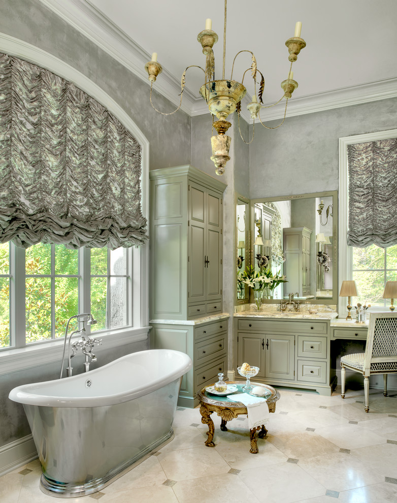 Klassisches Badezimmer mit Marmorboden, grauer Wandfarbe, freistehender Badewanne, beigen Fliesen, grünen Schränken, profilierten Schrankfronten und Unterbauwaschbecken in St. Louis