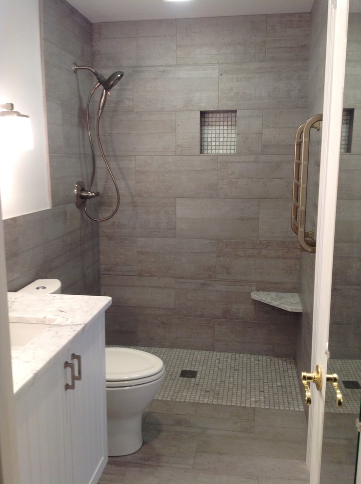 Cette photo montre une salle de bain moderne de taille moyenne avec un placard à porte affleurante, des portes de placard blanches, un carrelage beige, des carreaux de porcelaine, un mur beige, un sol en carrelage de porcelaine, un lavabo encastré, un plan de toilette en marbre, un sol beige et aucune cabine.