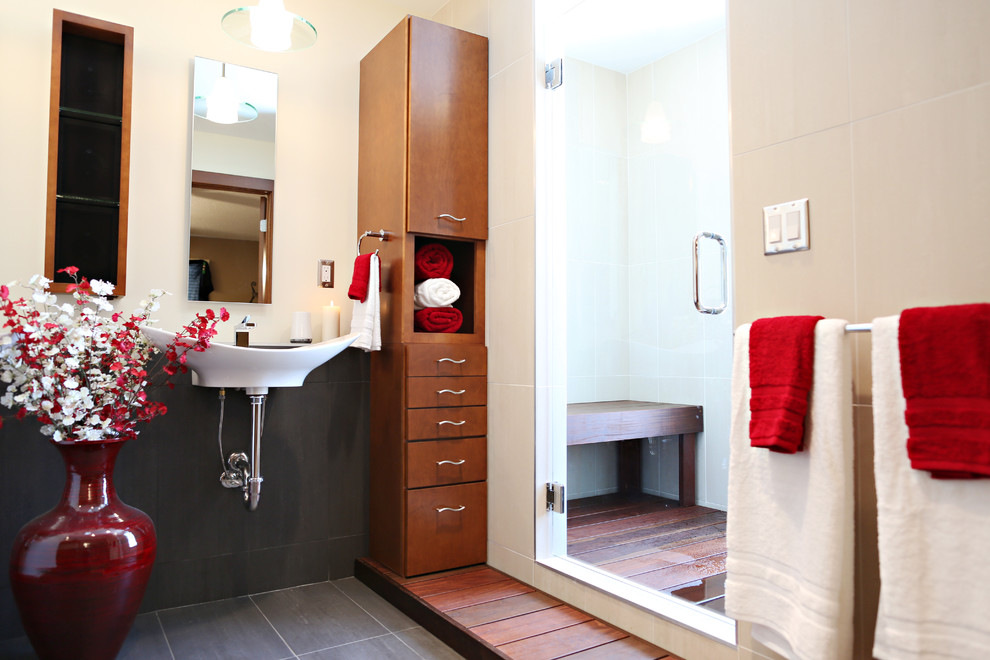 Photo of a medium sized contemporary bathroom in Minneapolis with a wall-mounted sink, flat-panel cabinets, medium wood cabinets, tiled worktops, a double shower, a one-piece toilet, grey tiles, ceramic tiles, white walls and ceramic flooring.