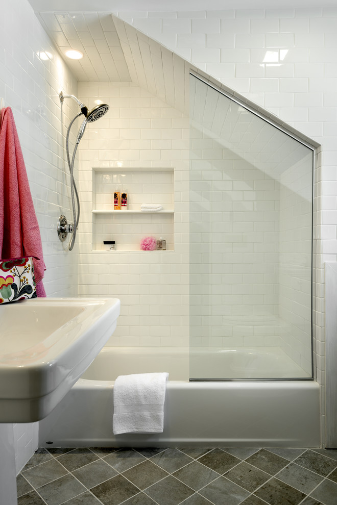 Klassisk inredning av ett litet badrum, med ett piedestal handfat, ett badkar i en alkov, en dusch/badkar-kombination, en toalettstol med separat cisternkåpa, vit kakel, keramikplattor, vita väggar och klinkergolv i keramik