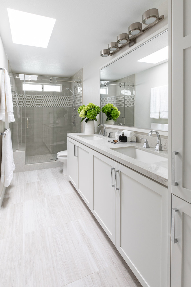 Klassisches Duschbad mit Schrankfronten im Shaker-Stil, weißen Schränken, Duschnische, weißer Wandfarbe, Unterbauwaschbecken, beigem Boden, Falttür-Duschabtrennung und beiger Waschtischplatte in San Diego
