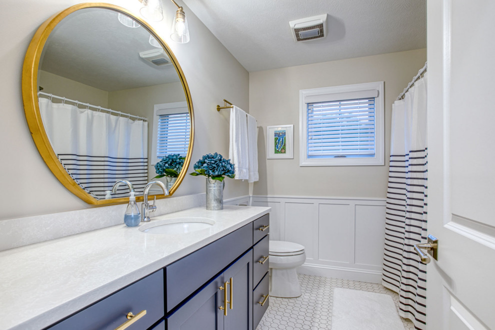 На фото: большая ванная комната в стиле неоклассика (современная классика) с фасадами в стиле шейкер, синими фасадами, душем над ванной, раздельным унитазом, бежевыми стенами, полом из керамогранита, душевой кабиной, врезной раковиной, белым полом, шторкой для ванной, белой столешницей, тумбой под одну раковину, встроенной тумбой и панелями на стенах с