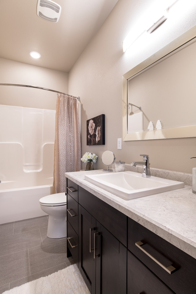 Inredning av ett modernt mellanstort grå grått badrum, med skåp i shakerstil, skåp i mörkt trä, en dusch/badkar-kombination, en toalettstol med hel cisternkåpa, beige väggar, ett nedsänkt handfat, laminatbänkskiva, grått golv och dusch med duschdraperi