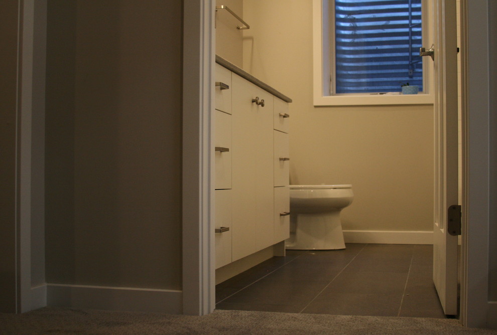 Immagine di una stanza da bagno minimalista con ante lisce, ante bianche, pareti beige e pavimento grigio