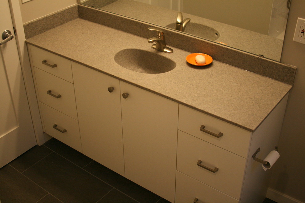 Exempel på ett modernt badrum, med släta luckor, vita skåp, beige väggar och grått golv