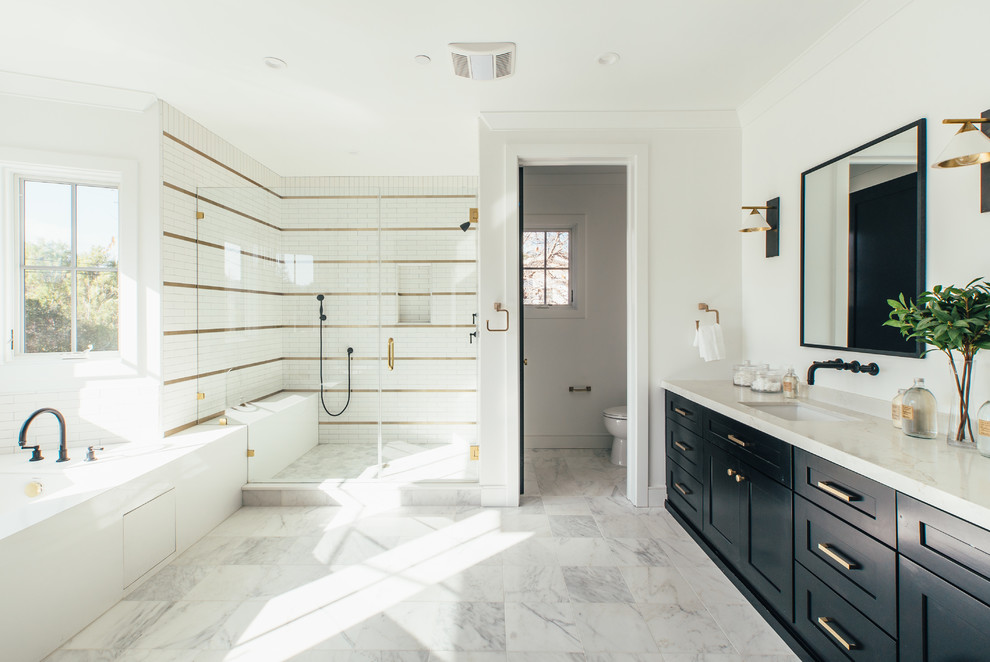 Photo of a farmhouse shower room bathroom in Los Angeles with shaker cabinets, black cabinets, an alcove bath, an alcove shower, white tiles, white walls, a submerged sink, white floors, a hinged door and beige worktops.