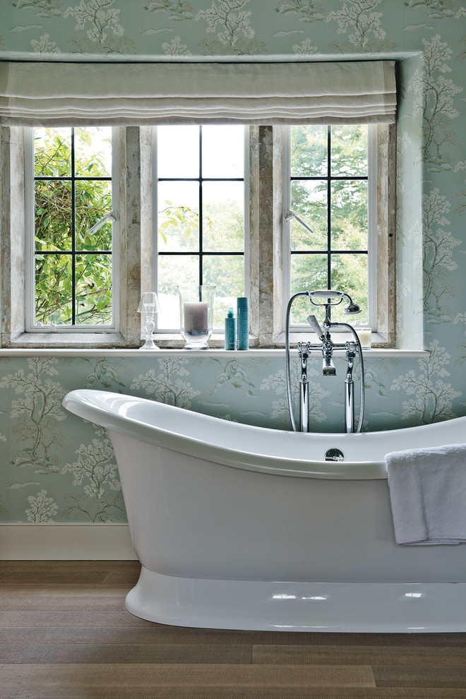Idee per una grande stanza da bagno padronale country con lavabo a colonna, vasca freestanding, pareti blu e parquet chiaro