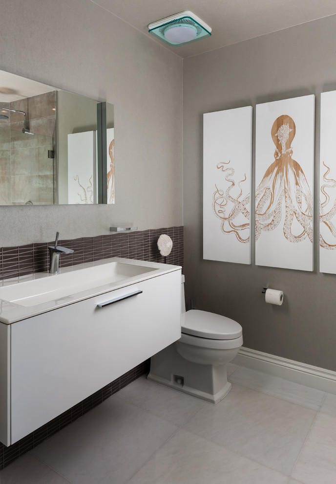 Ispirazione per una stanza da bagno con doccia minimal di medie dimensioni con ante lisce, ante bianche, pareti grigie, pavimento grigio, WC a due pezzi, lavabo integrato, top in marmo e top bianco