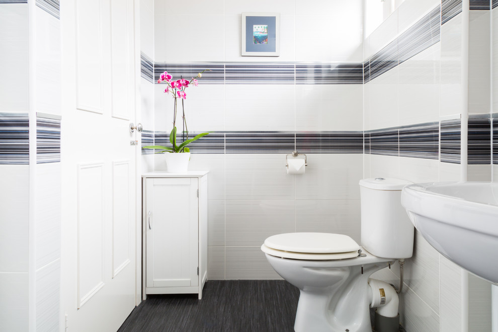 Medium sized modern shower room bathroom in Other with a pedestal sink, a walk-in shower, a one-piece toilet, white tiles, cement tiles, yellow walls and vinyl flooring.