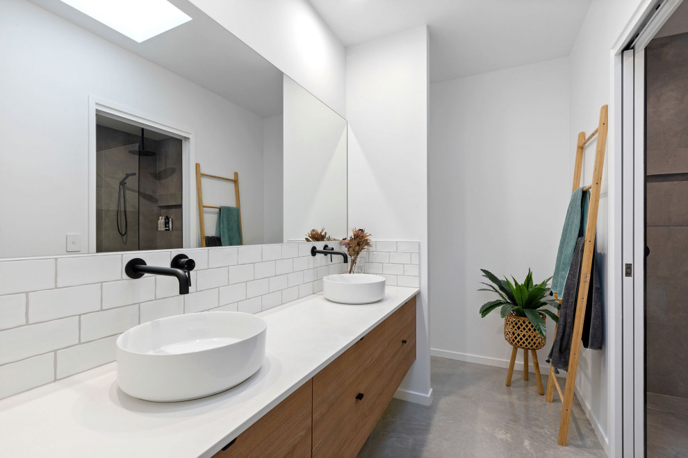 Idéer för ett stort modernt vit badrum med dusch, med släta luckor, skåp i mellenmörkt trä, vit kakel, tunnelbanekakel, vita väggar, ett fristående handfat och grått golv