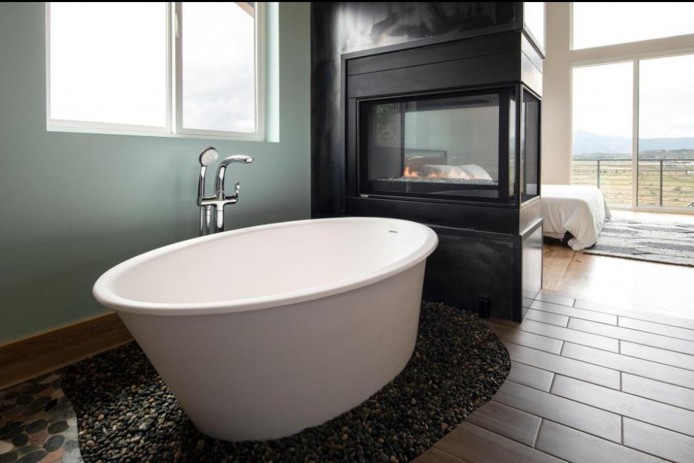 Свежая идея для дизайна: главная ванная комната среднего размера в стиле лофт с плоскими фасадами, отдельно стоящей ванной, полом из галечной плитки и черным полом - отличное фото интерьера