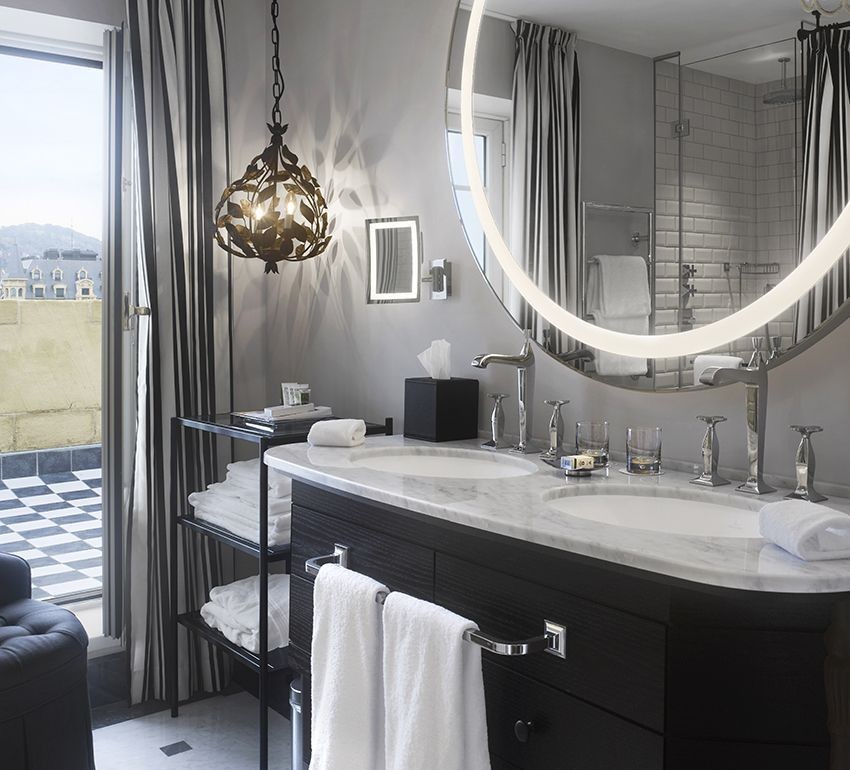 Ejemplo de cuarto de baño tradicional renovado de tamaño medio con lavabo bajoencimera, armarios con paneles lisos, puertas de armario negras, ducha empotrada, baldosas y/o azulejos grises, paredes grises y aseo y ducha