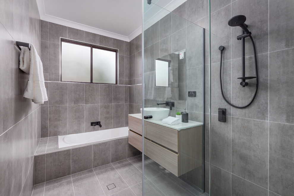 Inspiration för ett mellanstort funkis vit vitt badrum med dusch, med släta luckor, skåp i ljust trä, ett undermonterat badkar, grå kakel, ett fristående handfat och grått golv
