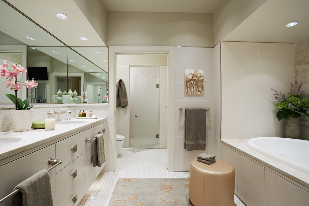 Cette photo montre une douche en alcôve principale tendance de taille moyenne avec un lavabo encastré, un placard à porte plane, des portes de placard beiges, une baignoire posée, un carrelage beige et un mur beige.