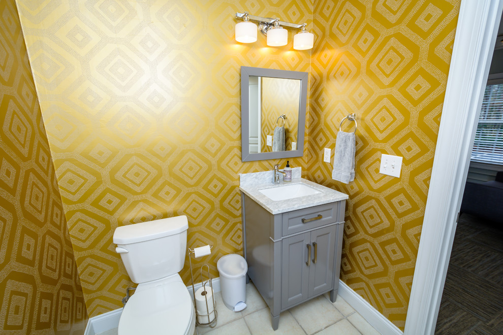 Пример оригинального дизайна: ванная комната среднего размера в стиле неоклассика (современная классика) с фасадами островного типа, серыми фасадами, раздельным унитазом, желтыми стенами, полом из керамогранита, душевой кабиной, врезной раковиной, мраморной столешницей, бежевым полом и белой столешницей
