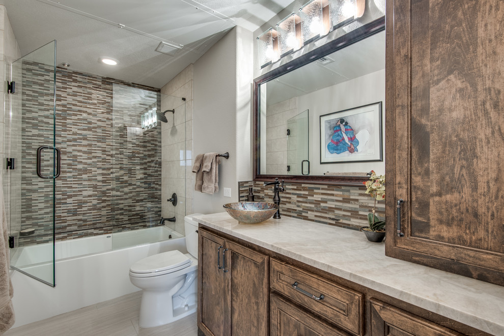 Inspiration for a small southwestern 3/4 multicolored tile and mosaic tile porcelain tile and beige floor bathroom remodel in Dallas with beaded inset cabinets, medium tone wood cabinets, a two-piece toilet, a vessel sink, quartzite countertops, a hinged shower door and white countertops