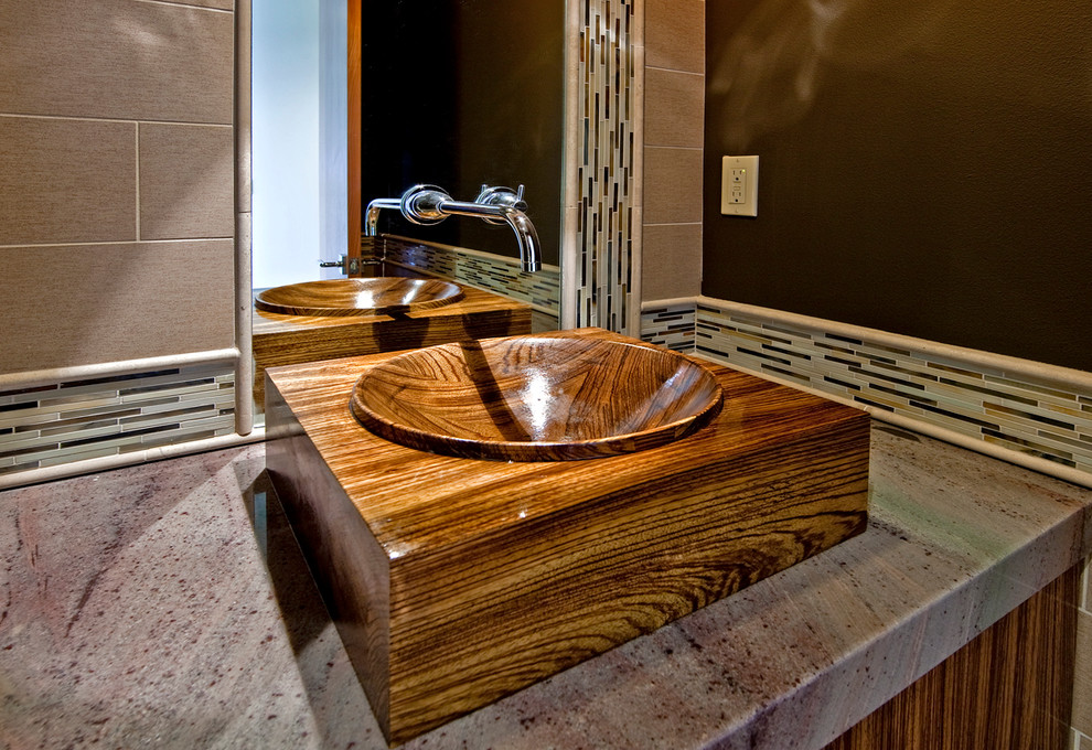 Exemple d'une salle de bain éclectique en bois brun avec une vasque, un placard à porte plane, un plan de toilette en granite et un mur marron.