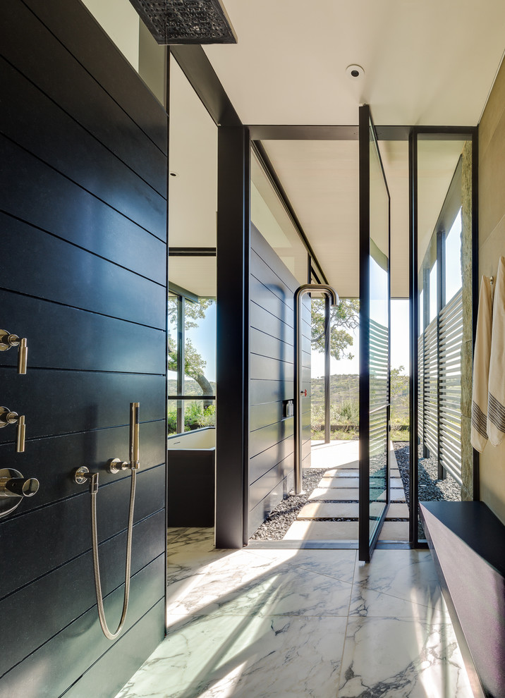 Immagine di una stanza da bagno padronale contemporanea di medie dimensioni con vasca freestanding, doccia aperta, piastrelle nere, lastra di pietra, pareti nere, pavimento in marmo e doccia aperta