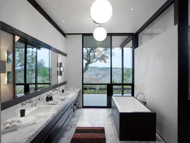 Exemple d'une salle de bain principale tendance en bois foncé de taille moyenne avec un placard à porte plane, une baignoire indépendante, un carrelage blanc, des dalles de pierre, un mur blanc, un sol en marbre, un lavabo encastré et un plan de toilette en marbre.