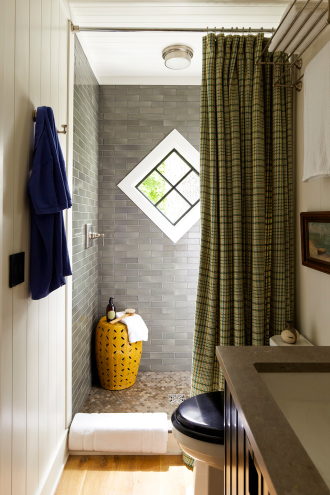 Example of a beach style gray tile bathroom design in New York with an undermount sink, a two-piece toilet and brown countertops