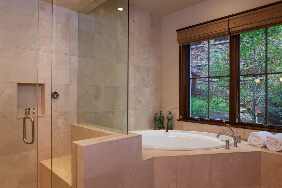 Foto di una stanza da bagno padronale tradizionale di medie dimensioni con vasca ad angolo, doccia alcova, piastrelle beige, piastrelle in ceramica, pareti beige, pavimento con piastrelle in ceramica e top piastrellato
