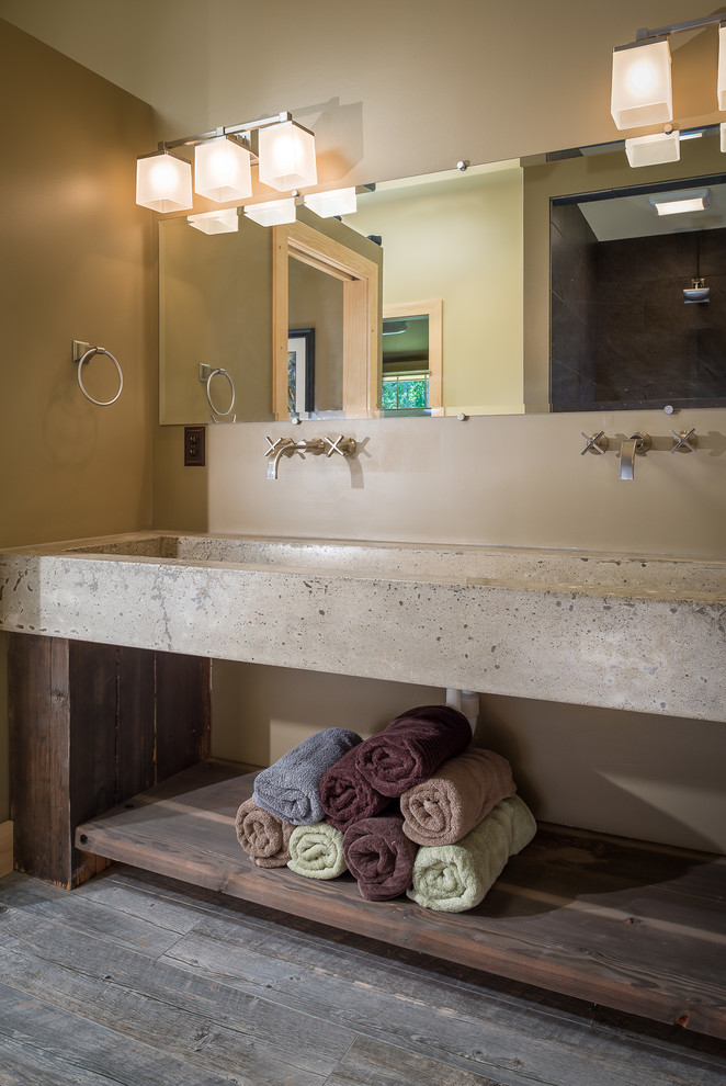 Imagen de cuarto de baño principal rural con paredes beige, suelo de madera en tonos medios, lavabo de seno grande y encimera de cemento