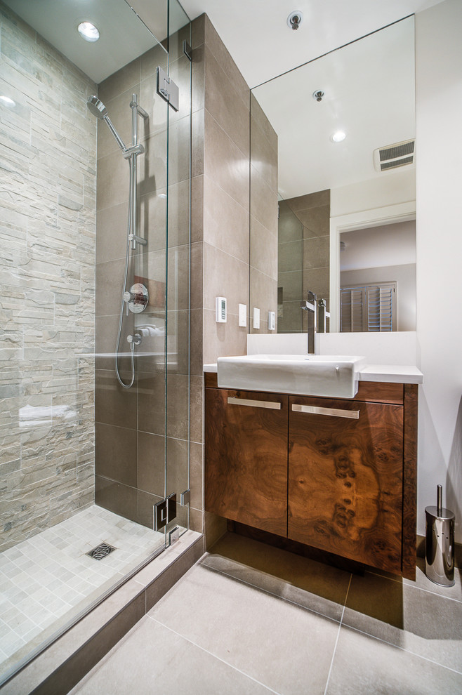 Immagine di una stanza da bagno contemporanea con lavabo a bacinella, ante lisce, ante in legno bruno, doccia alcova e piastrelle beige