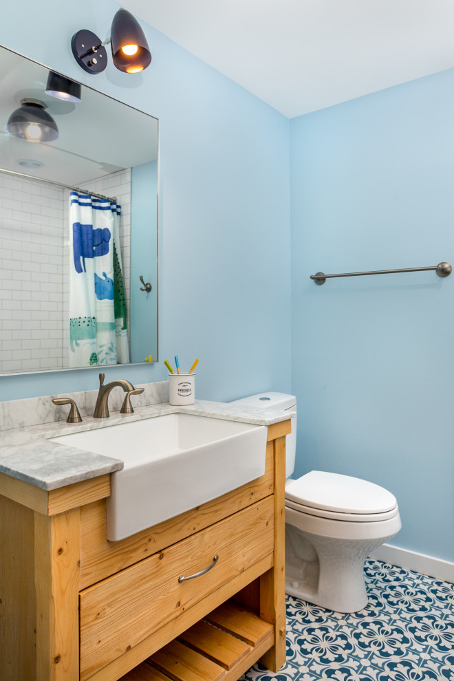 Idéer för rustika vitt badrum för barn, med skåp i ljust trä, ett badkar i en alkov, en dusch/badkar-kombination, en toalettstol med hel cisternkåpa, tunnelbanekakel, blå väggar, klinkergolv i porslin, ett integrerad handfat, bänkskiva i kvartsit, blått golv, dusch med duschdraperi och släta luckor
