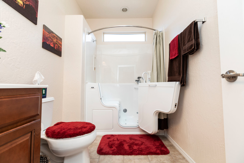 Example of a small classic 3/4 white tile ceramic tile and beige floor bathroom design in Albuquerque with raised-panel cabinets, medium tone wood cabinets, a one-piece toilet, white walls, a hinged shower door and white countertops