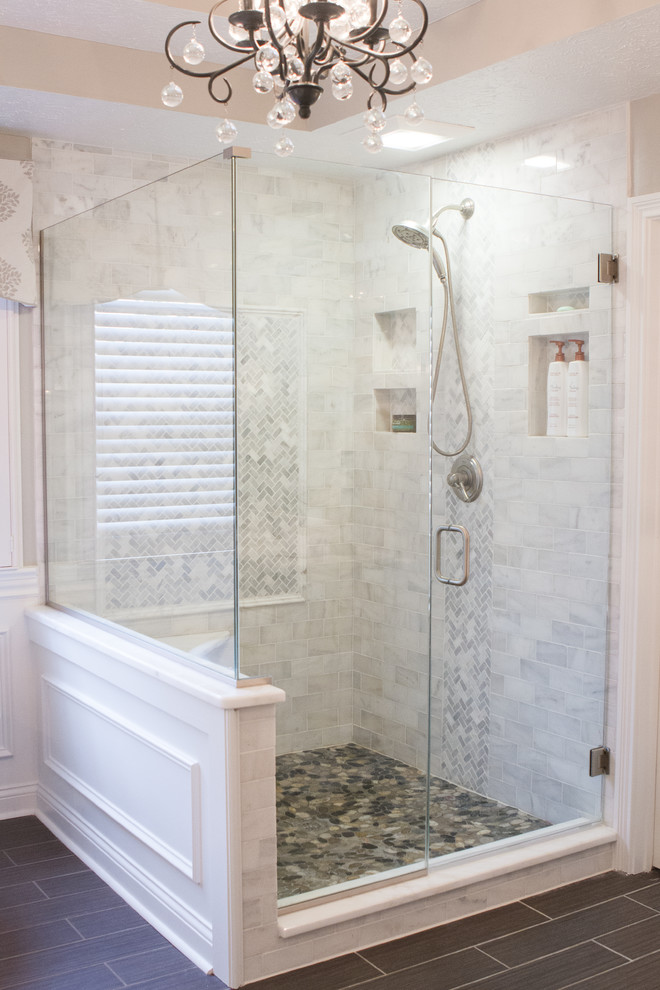 Design ideas for a large contemporary ensuite bathroom in Indianapolis with recessed-panel cabinets, white cabinets, a freestanding bath, a corner shower, grey tiles, white tiles, stone tiles, white walls, porcelain flooring, a submerged sink and marble worktops.