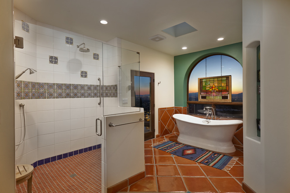 На фото: огромная главная ванная комната в стиле фьюжн с фасадами островного типа, светлыми деревянными фасадами, отдельно стоящей ванной, душем без бортиков, унитазом-моноблоком, разноцветной плиткой, терракотовой плиткой, коричневыми стенами, полом из терракотовой плитки, настольной раковиной и столешницей из плитки с