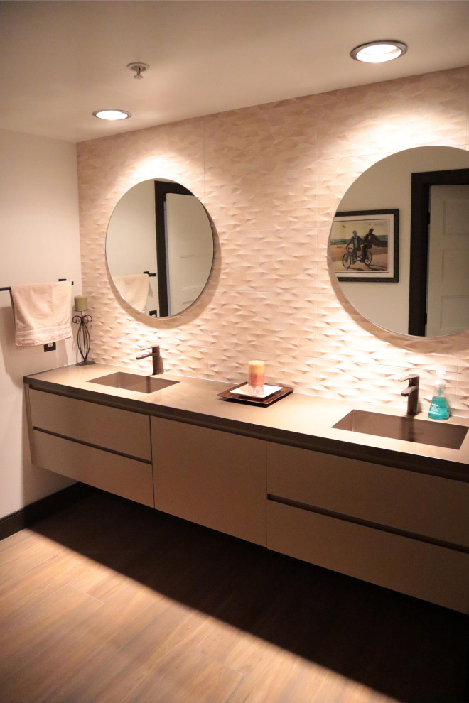 Idéer för att renovera ett mellanstort funkis beige beige badrum med dusch, med släta luckor, bruna skåp, vit kakel, porslinskakel, vita väggar, klinkergolv i porslin, ett integrerad handfat, bänkskiva i kvarts och brunt golv