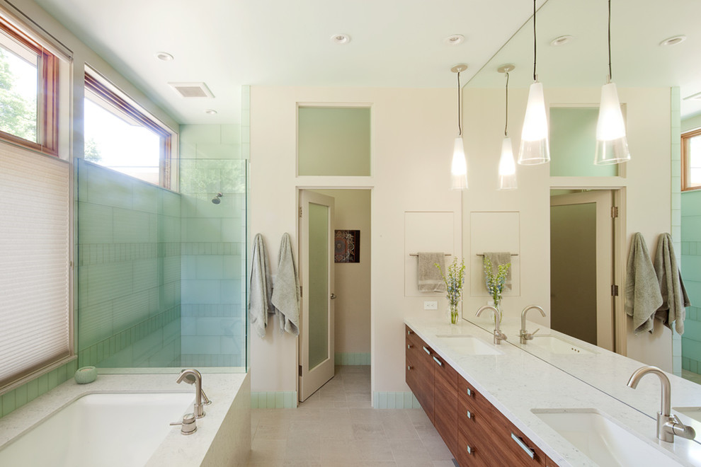 Photo of a large contemporary ensuite bathroom in Portland with flat-panel cabinets, medium wood cabinets, a submerged bath, a corner shower, green tiles, glass tiles, beige walls, porcelain flooring, a submerged sink and engineered stone worktops.