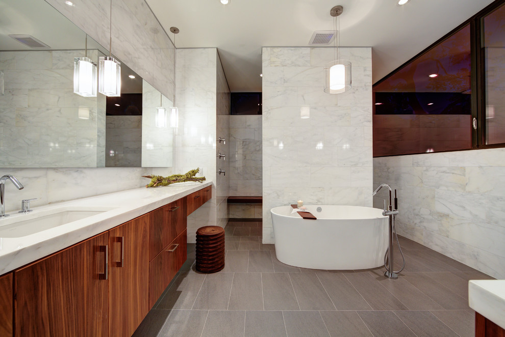 Foto på ett funkis badrum, med ett undermonterad handfat, släta luckor, skåp i mörkt trä, ett fristående badkar, en öppen dusch, vit kakel och med dusch som är öppen
