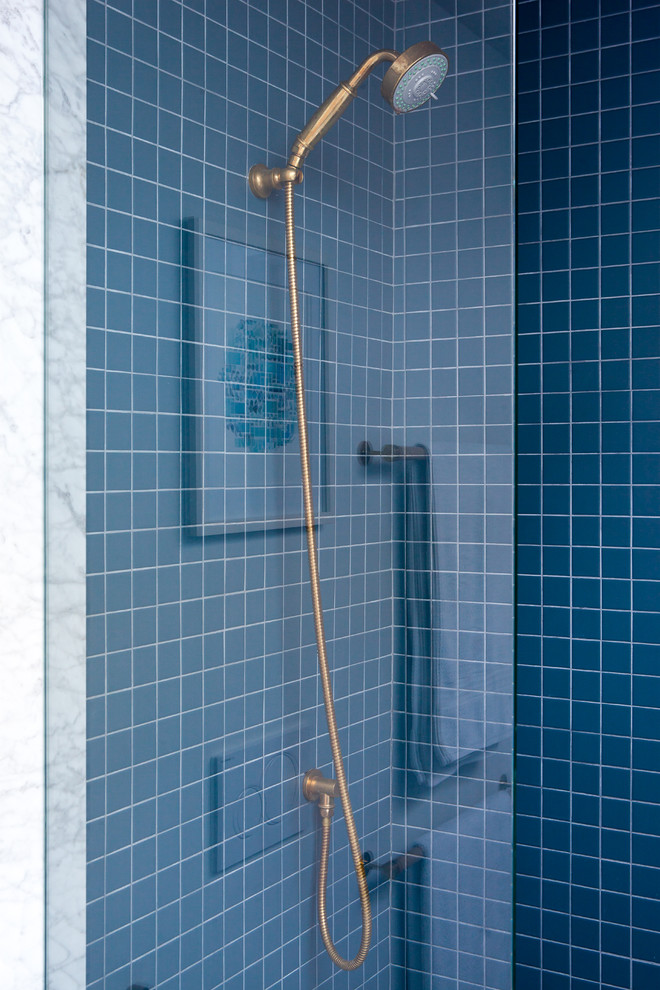 Modern inredning av ett litet en-suite badrum, med en dusch i en alkov, blå kakel, glaskakel, dusch med gångjärnsdörr, en vägghängd toalettstol, vita väggar, marmorgolv, ett undermonterad handfat, marmorbänkskiva och grått golv