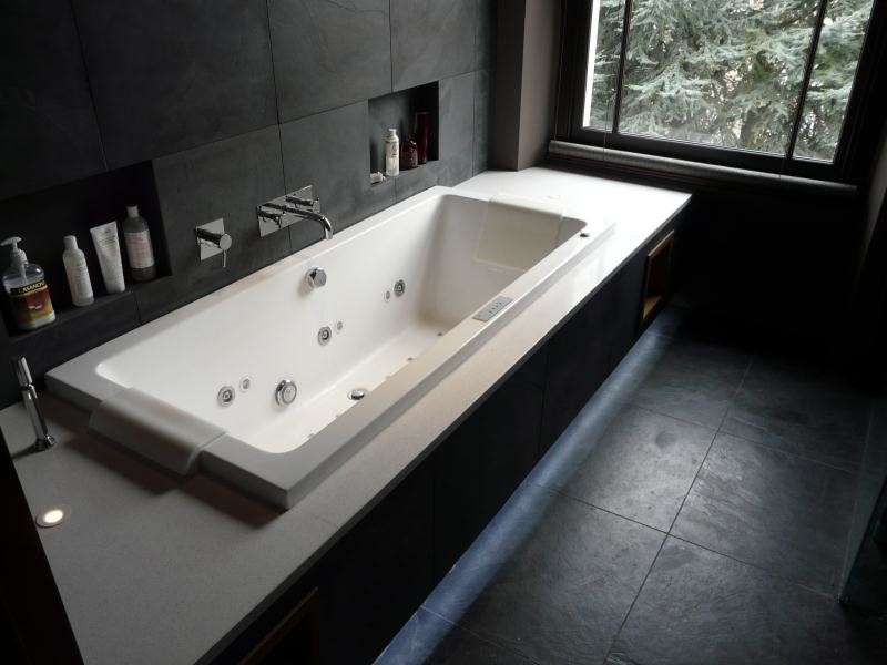 Inspiration för ett mellanstort funkis en-suite badrum, med bänkskiva i kvarts, ett platsbyggt badkar, svart kakel, stenkakel, svarta väggar och skiffergolv